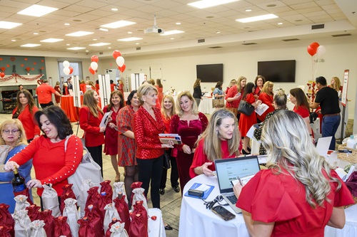 Crowds of women dressed in red looking at auction packages.
